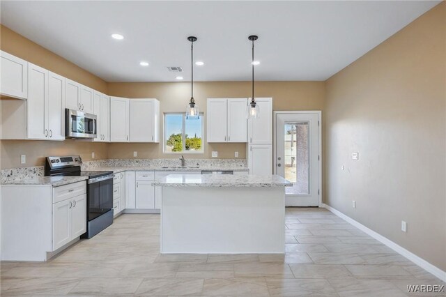 kitchen with visible vents, white cabinets, appliances with stainless steel finishes, a center island, and a sink