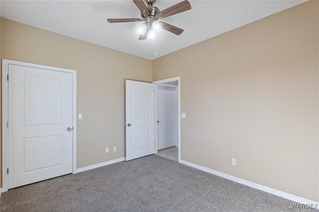 unfurnished bedroom with a ceiling fan, carpet flooring, and baseboards