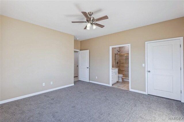 unfurnished bedroom with baseboards, ensuite bathroom, a ceiling fan, and light colored carpet