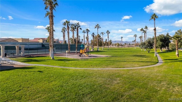 surrounding community featuring playground community, fence, and a lawn