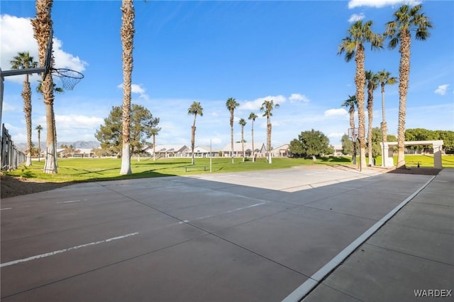 view of sport court featuring a residential view, community basketball court, and a lawn