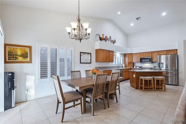 dining space featuring light tile patterned floors, a notable chandelier, visible vents, and high vaulted ceiling