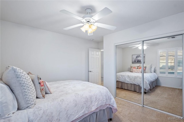 bedroom featuring light carpet, a closet, visible vents, and a ceiling fan