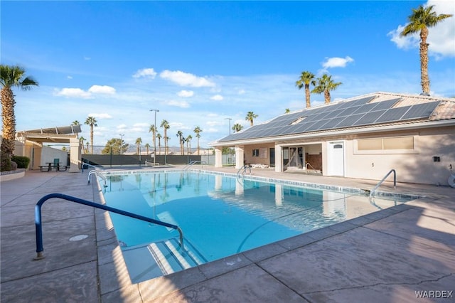 community pool with fence and a patio