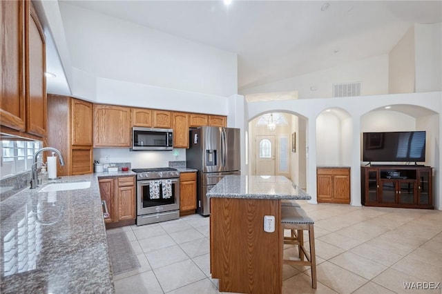 kitchen with stone countertops, visible vents, stainless steel appliances, and a sink