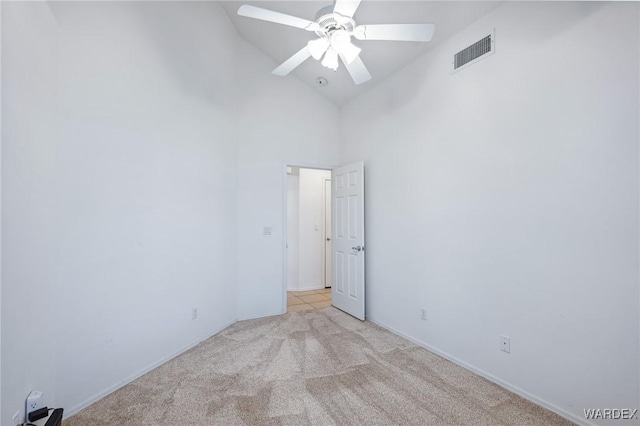 unfurnished room with high vaulted ceiling, ceiling fan, visible vents, and light colored carpet