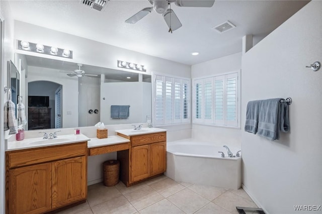 full bath featuring tile patterned flooring, visible vents, a garden tub, and a sink