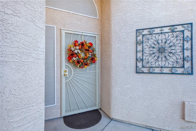 doorway to property featuring stucco siding