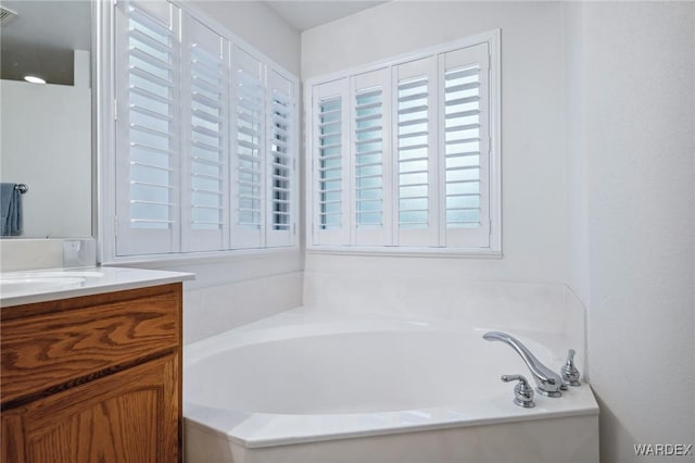 full bathroom featuring a garden tub and vanity