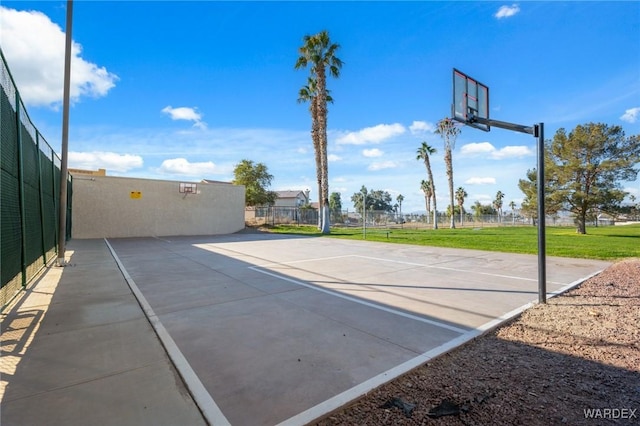 view of sport court featuring community basketball court, a lawn, and fence