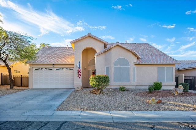 view of front of house with an attached garage, fence, a tiled roof, concrete driveway, and stucco siding