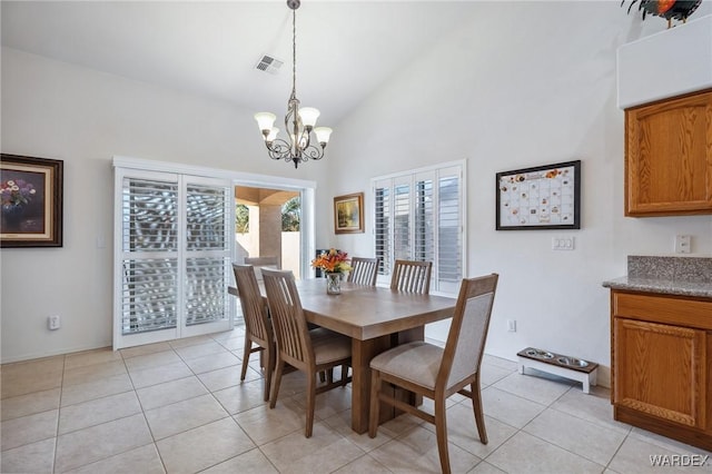 dining room featuring light tile patterned floors, high vaulted ceiling, visible vents, and an inviting chandelier