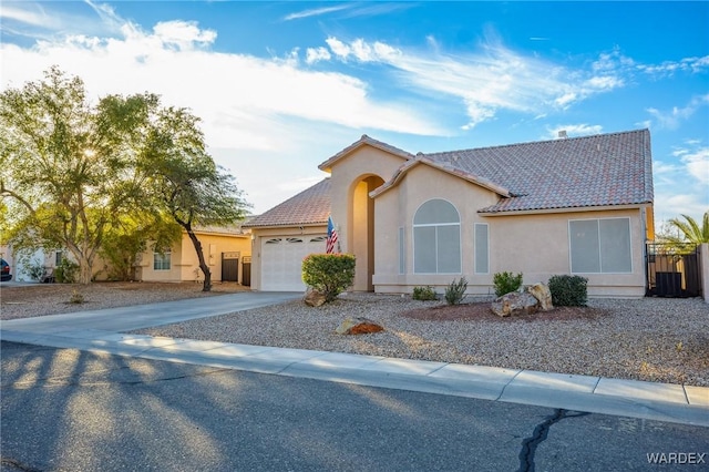 view of front of home featuring a garage, driveway, a tile roof, and stucco siding