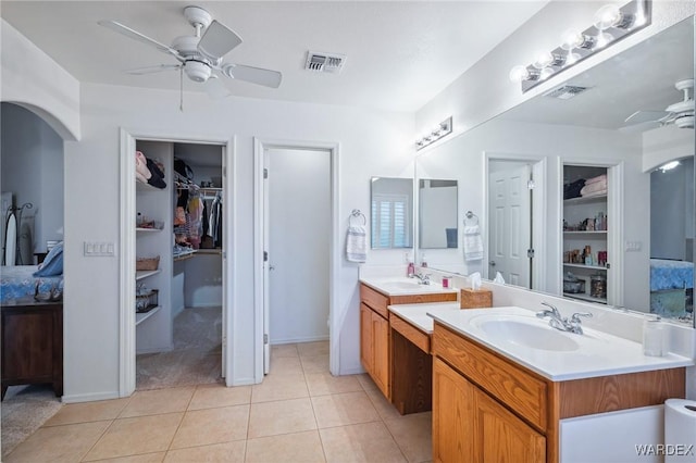 full bathroom with a walk in closet, visible vents, ceiling fan, vanity, and tile patterned floors