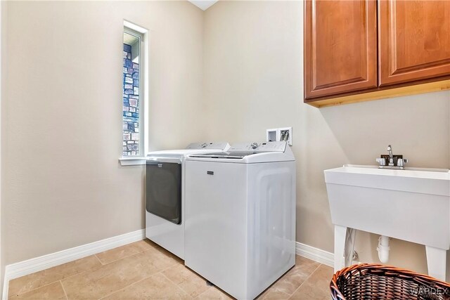 laundry room featuring light tile patterned floors, cabinet space, baseboards, and separate washer and dryer