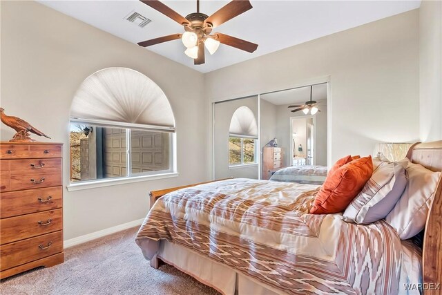 bedroom featuring light carpet, a ceiling fan, visible vents, baseboards, and a closet