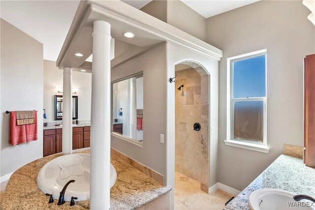 bathroom with two vanities, a sink, decorative columns, and a walk in shower