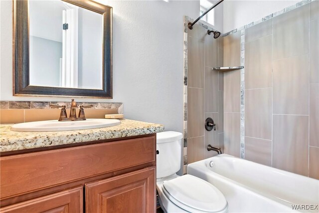 bathroom with shower / tub combination, vanity, and toilet