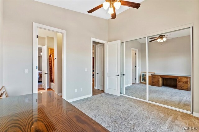 unfurnished bedroom with a closet, carpet flooring, ceiling fan, and baseboards