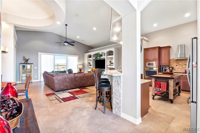 living room with light tile patterned floors, high vaulted ceiling, recessed lighting, a ceiling fan, and baseboards