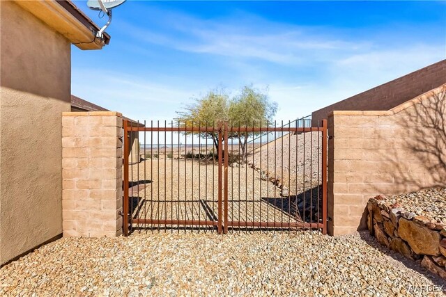 view of gate with a water view and fence