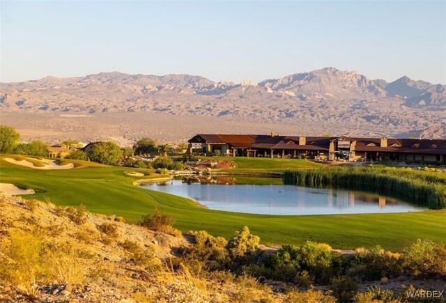 view of home's community with a yard, golf course view, and a water and mountain view