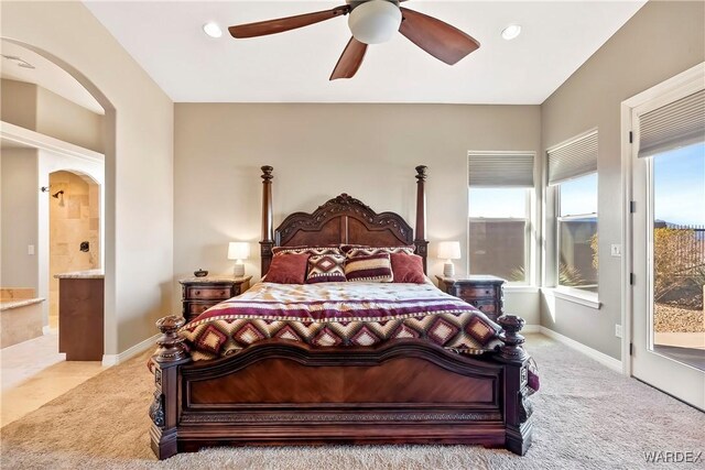 bedroom with arched walkways, light colored carpet, ceiling fan, access to outside, and baseboards