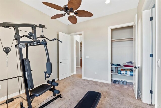 workout room with light colored carpet, ceiling fan, and baseboards