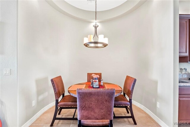 dining room with an inviting chandelier, baseboards, and light tile patterned flooring