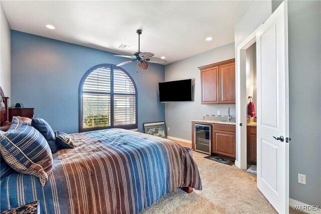 bedroom featuring beverage cooler, light carpet, a sink, visible vents, and indoor wet bar