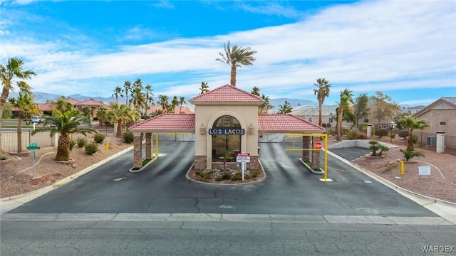 view of street featuring curbs, a mountain view, and a gated entry