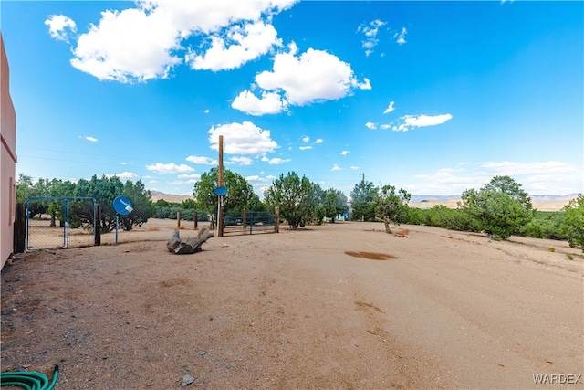 view of yard with a gate, a mountain view, and fence