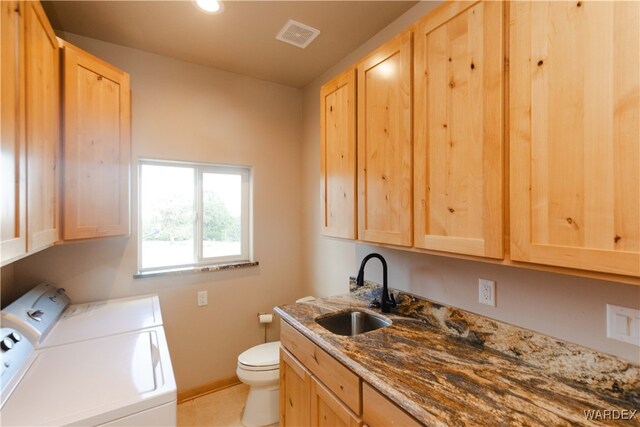 clothes washing area with laundry area, baseboards, visible vents, washer and clothes dryer, and a sink