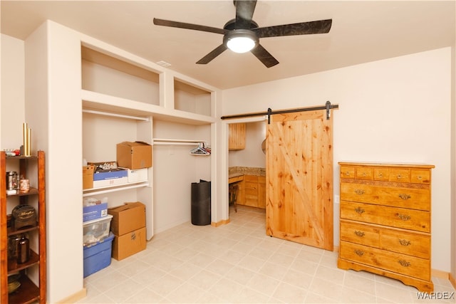 bedroom with ceiling fan and a barn door