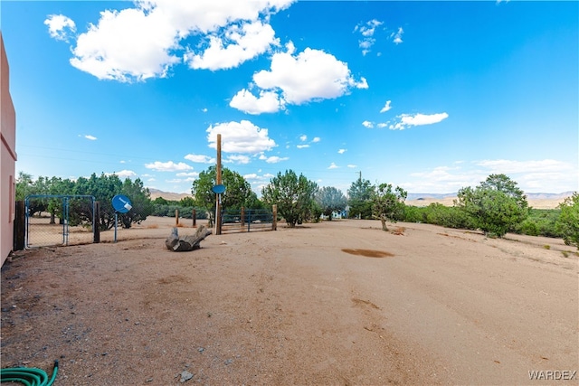 view of yard with a gate, a mountain view, and fence