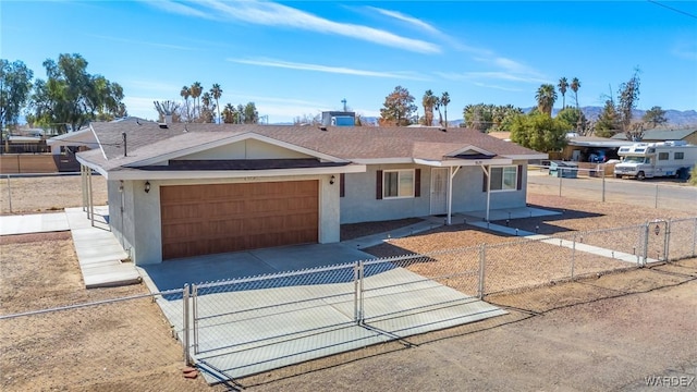 ranch-style house featuring a garage, concrete driveway, a fenced front yard, and stucco siding