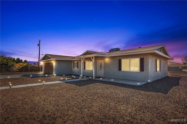 ranch-style home featuring a garage, concrete driveway, a patio, fence, and stucco siding