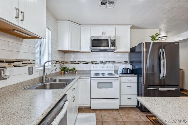 kitchen with appliances with stainless steel finishes, visible vents, a sink, and white cabinetry