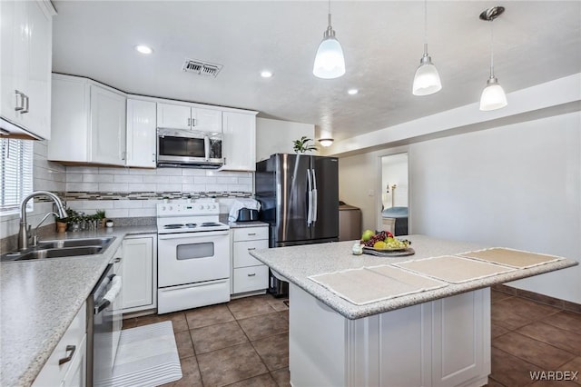 kitchen with visible vents, stainless steel appliances, light countertops, white cabinetry, and a sink