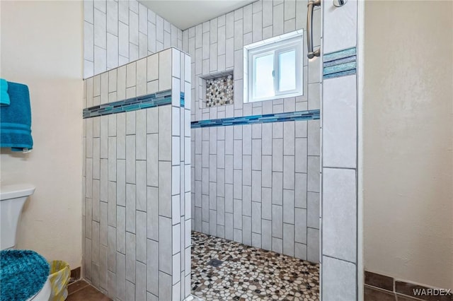 bathroom featuring a walk in shower and toilet