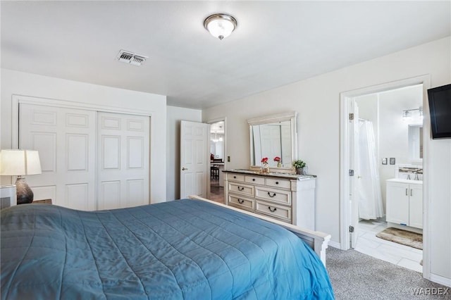 bedroom with connected bathroom, light colored carpet, visible vents, baseboards, and a closet