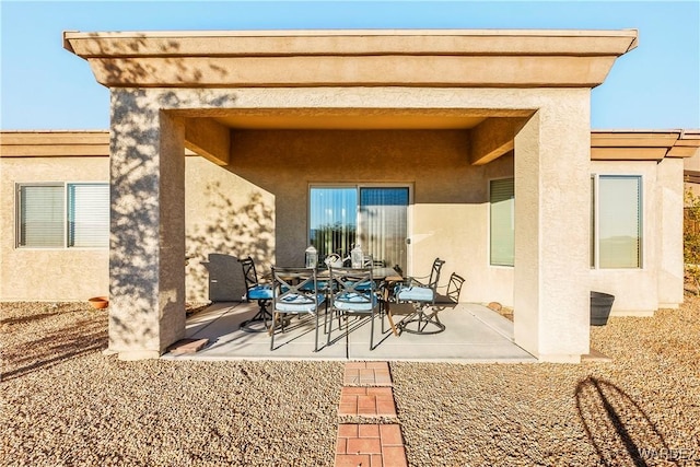 rear view of property with a patio and stucco siding