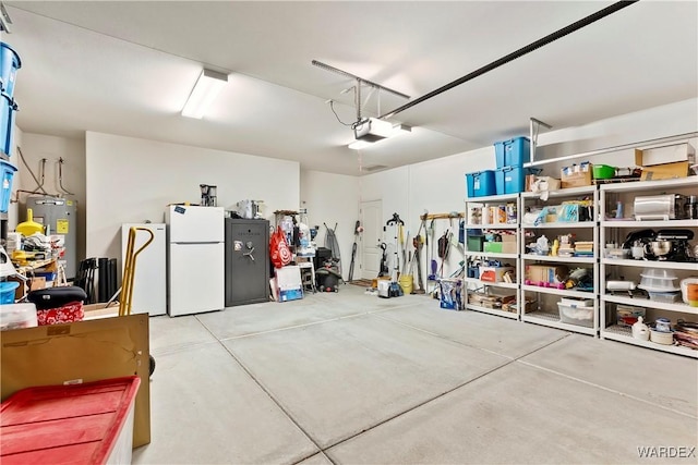 garage featuring a garage door opener, freestanding refrigerator, electric water heater, and fridge