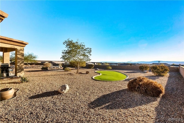 view of yard featuring a fenced backyard and a mountain view