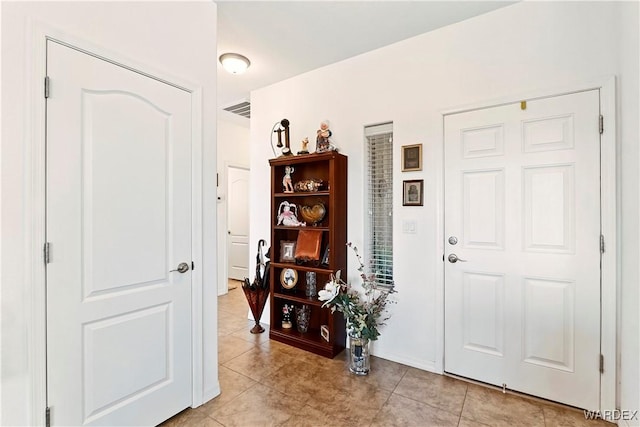 foyer with light tile patterned floors and visible vents