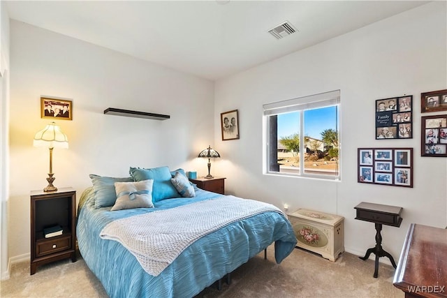 bedroom featuring baseboards, visible vents, and light colored carpet