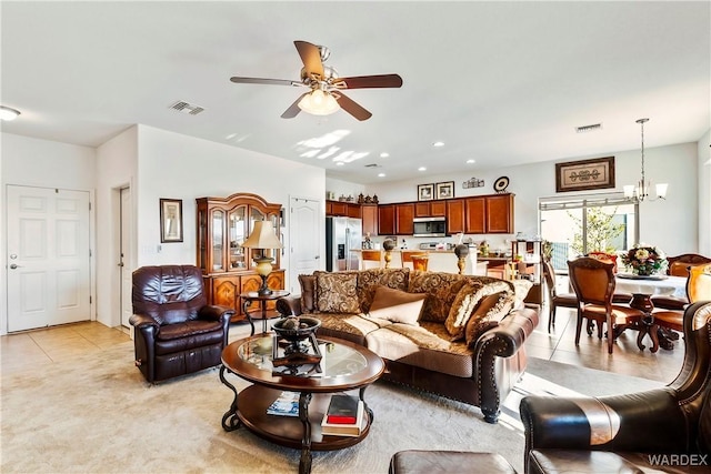 living area with light tile patterned flooring, recessed lighting, visible vents, and ceiling fan with notable chandelier