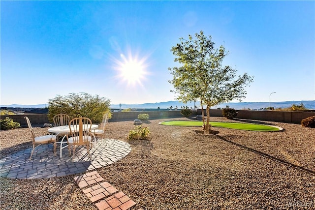 view of yard with a patio area, a mountain view, and fence