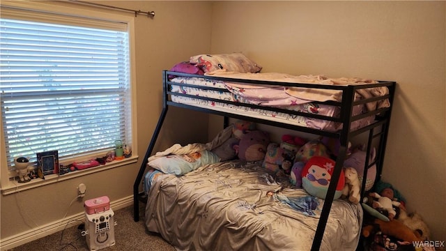 carpeted bedroom with multiple windows and baseboards