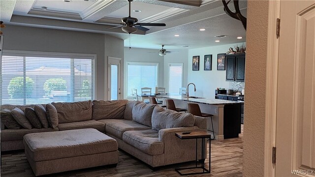 living area featuring coffered ceiling, visible vents, dark wood-style floors, beamed ceiling, and crown molding